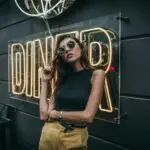 woman standing in front of Diner neon signage