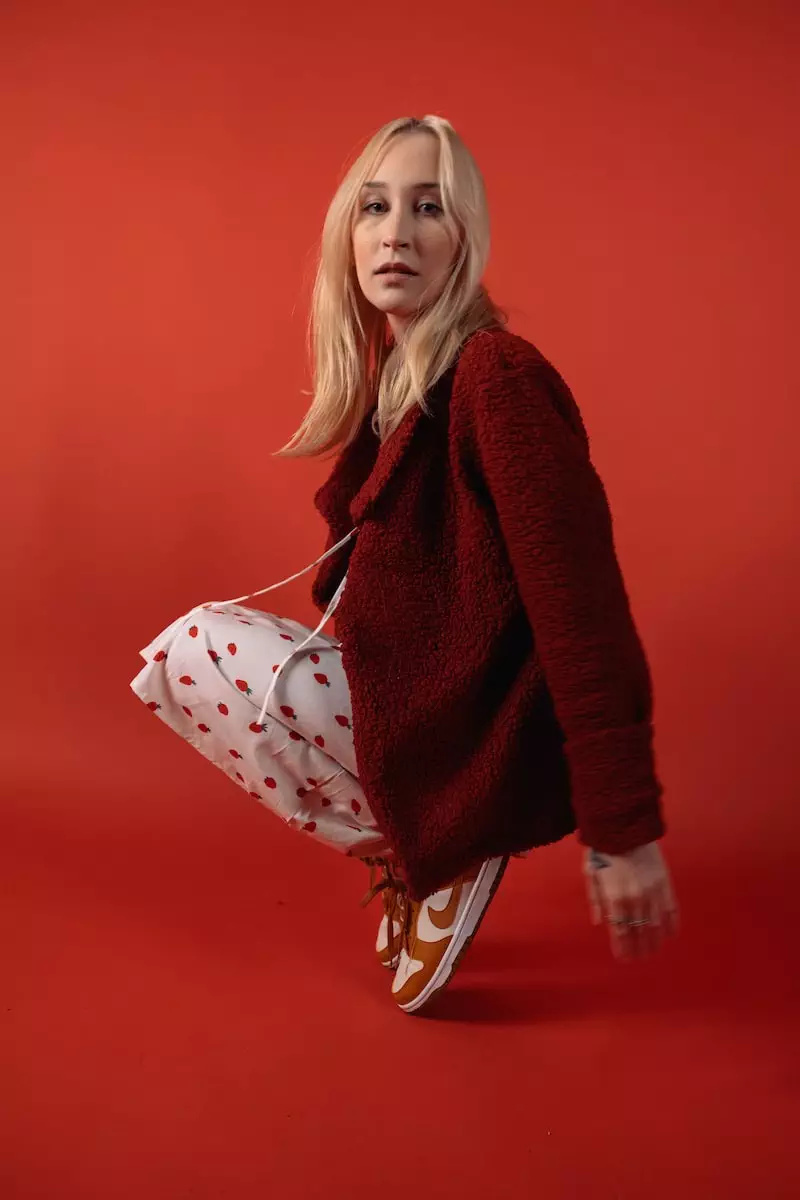 a woman in a red sweater is holding a white bag